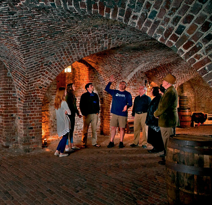 A guide with a tour group in a brick cellar